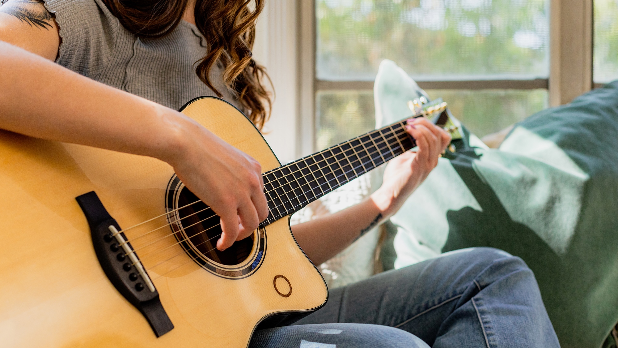 Close-up of a person playing the TAS3 C acoustic guitar.