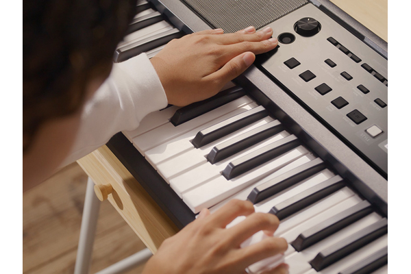 Girl tries different ways of playing with the PSR-E383.