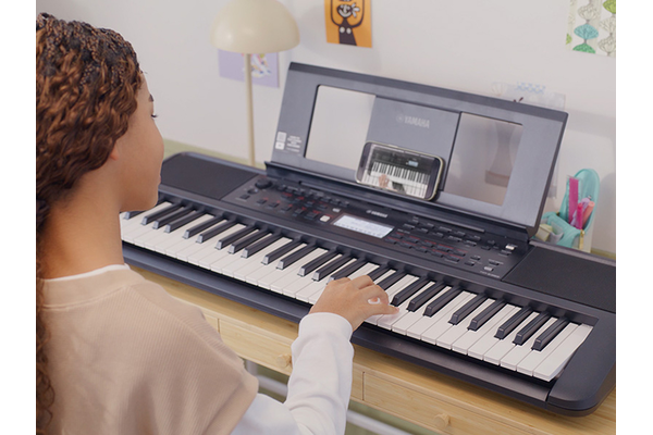 Girl is playing the PSR-E383 with satisfaction.