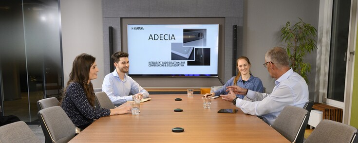 Meeting scene showing the Tabletop Microphones Solution delivering clear sound for office conferencing