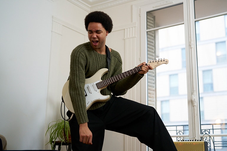 A man enthusiastically playing an electric guitar