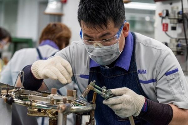 Un artisan soude des pièces métalliques avec de la soudure sans plomb.