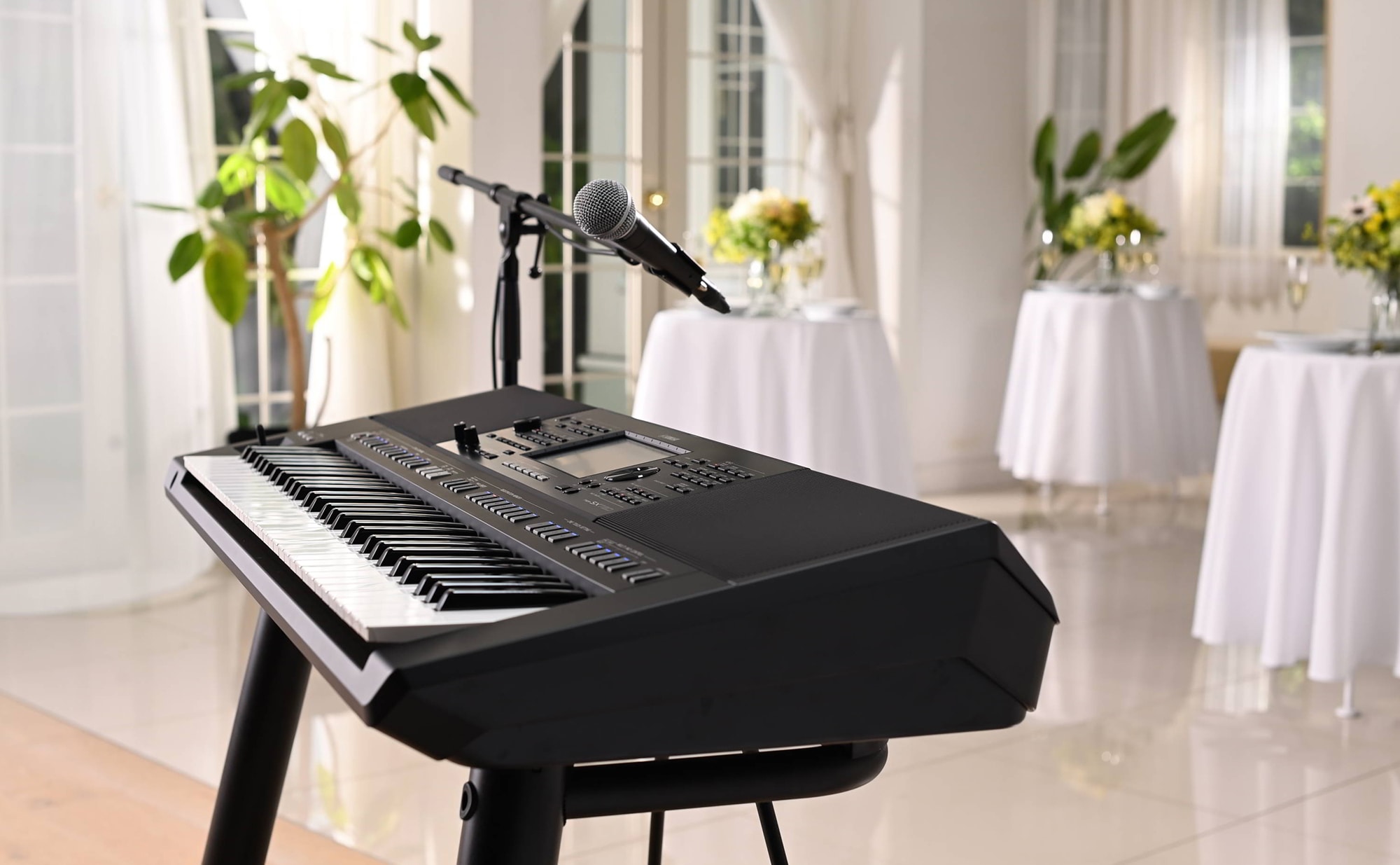 Yamaha Arranger Workstation PSR-SX720 with microphone stand at a party venue