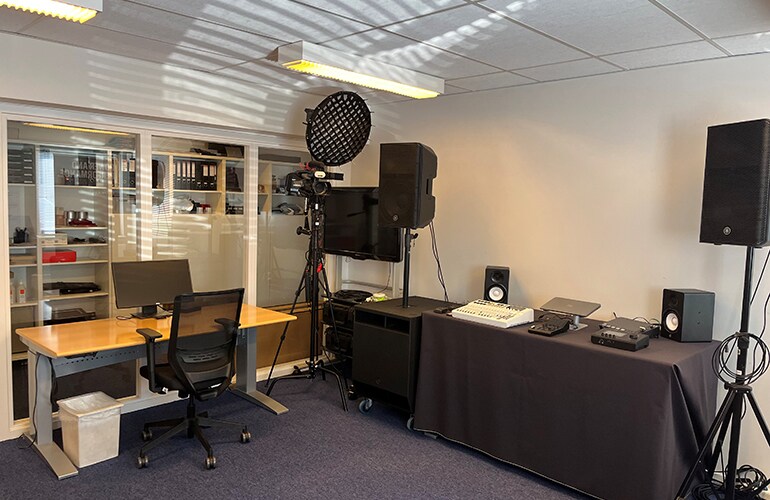 Centre de formation de Copenhague avec écran de présentation, tables et équipement audio.
