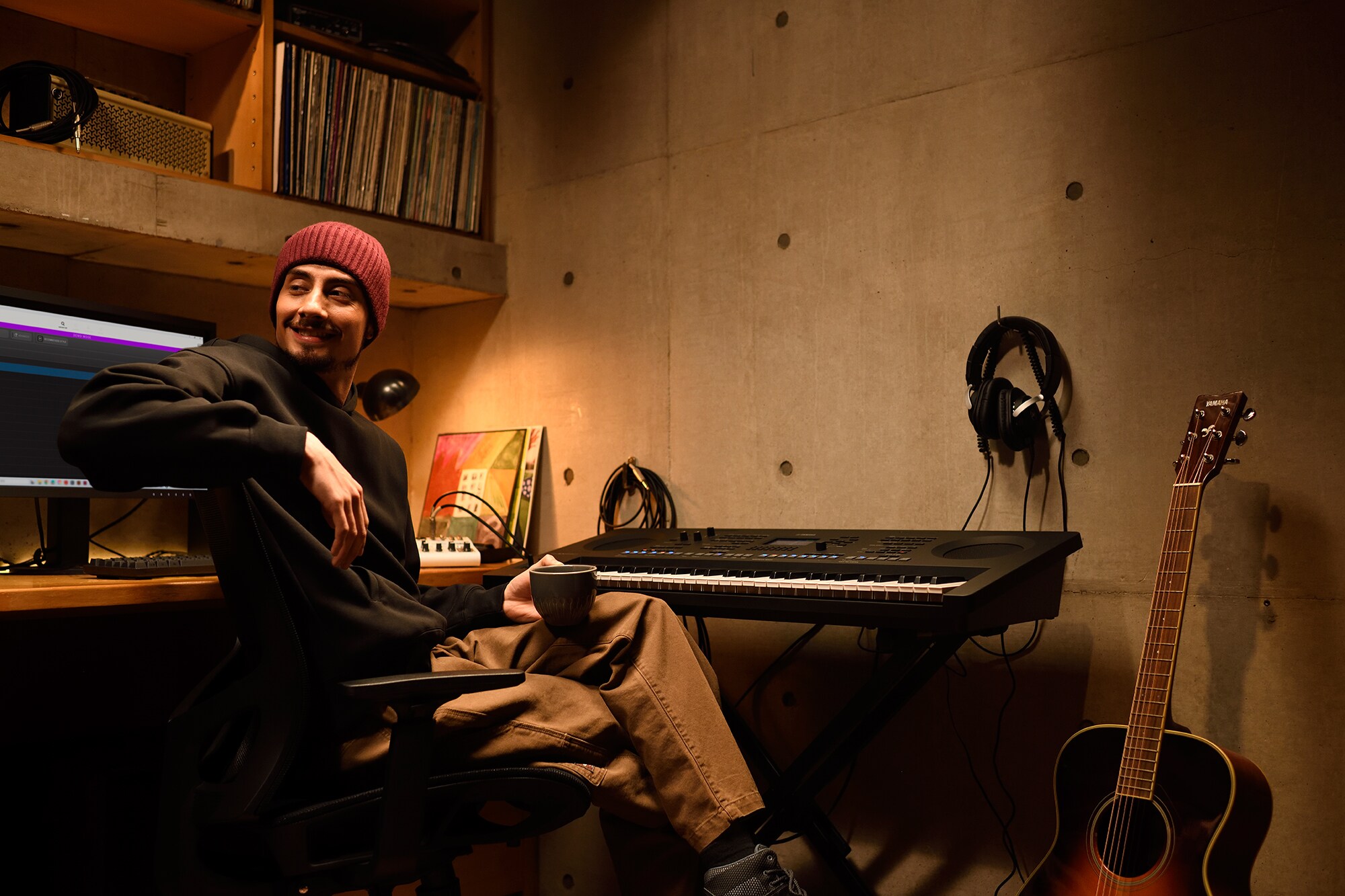 Un espace de création musicale à domicile avec un ordinateur et un clavier, mettant en scène un claviériste travaillant dans son studio maison