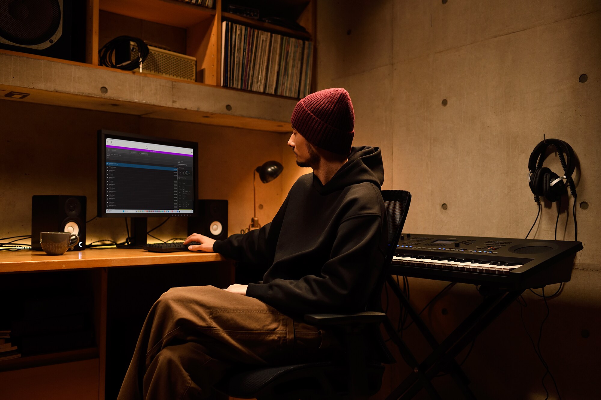 Un espace de création musicale à domicile avec un ordinateur et un clavier, mettant en scène un claviériste travaillant dans son studio maison