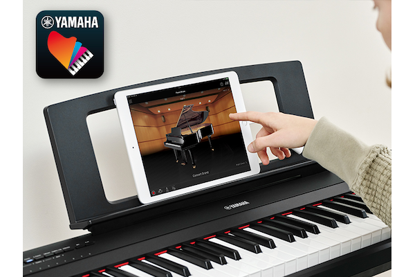 The Yamaha “Smart Pianist” app icon, together with a tablet placed on the music stand of the Piaggero