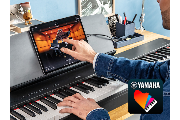 The Yamaha “Smart Pianist” app icon, together with a tablet placed on the m ature imageusic stand of the P-225