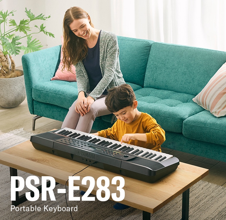 Parent and child happily playing the PSR-E283 on the table