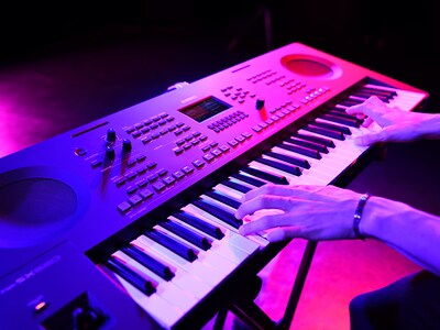 Gros plan de mains jouant sur un clavier lors d'une performance en direct.