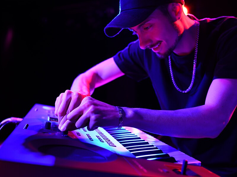 Un musicien ajustant les boutons Live Control d'un PSR-SX620 lors d'une performance en direct.