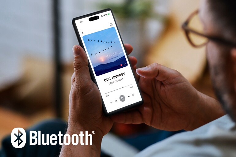 Le logo Bluetooth et un homme utilisant un téléphone intelligent pour lire de la musique.