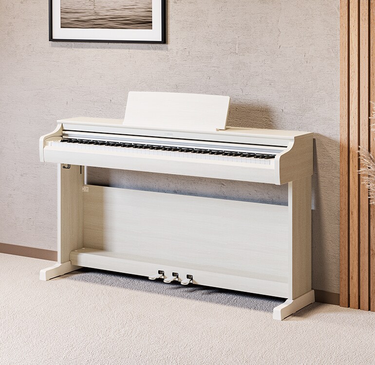 Un salon mettant en vedette un piano ARIUS en bouleau blanc avec des plantes d'intérieur et un canapé, s'intégrant harmonieusement au décor