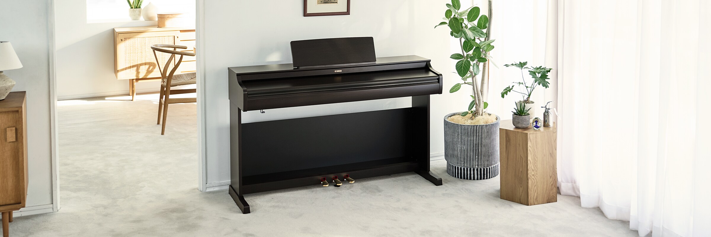 Un piano ARIUS dans un salon avec son couvercle fermé, s'intégrant harmonieusement au décor