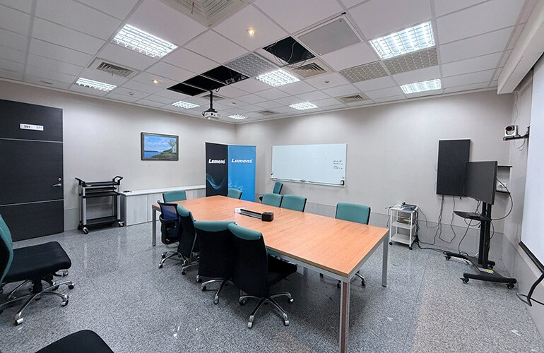 Centre de formation de Hsinchu avec table de réunion, écran d'affichage et équipement de présentation.