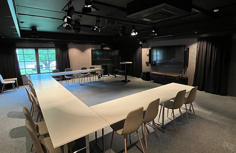 Centre de formation de Göteborg avec grande table de conférence, enceintes de plafond et système de présentation.