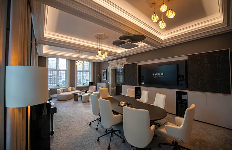 Salle de réunion du centre de formation de Londres avec tables, sièges et écran d'affichage.