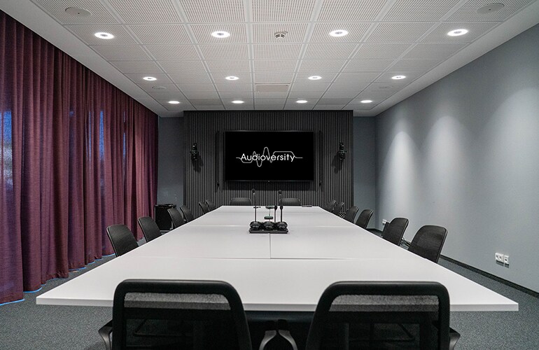 Centre de formation de Rellingen avec tables, chaises et écran de présentation.