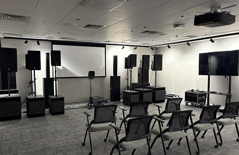 Salle du centre de formation de Bengaluru avec écran de présentation, sièges et équipement audio.