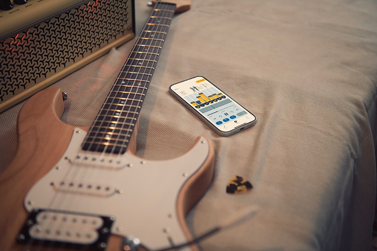 L'application de pratique musicale Extrack à côté d'une guitare électrique et d'un amplificateur