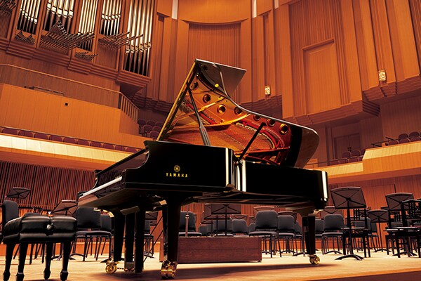 Piano à queue de concert Yamaha CFX sur la scène d'une salle de concert