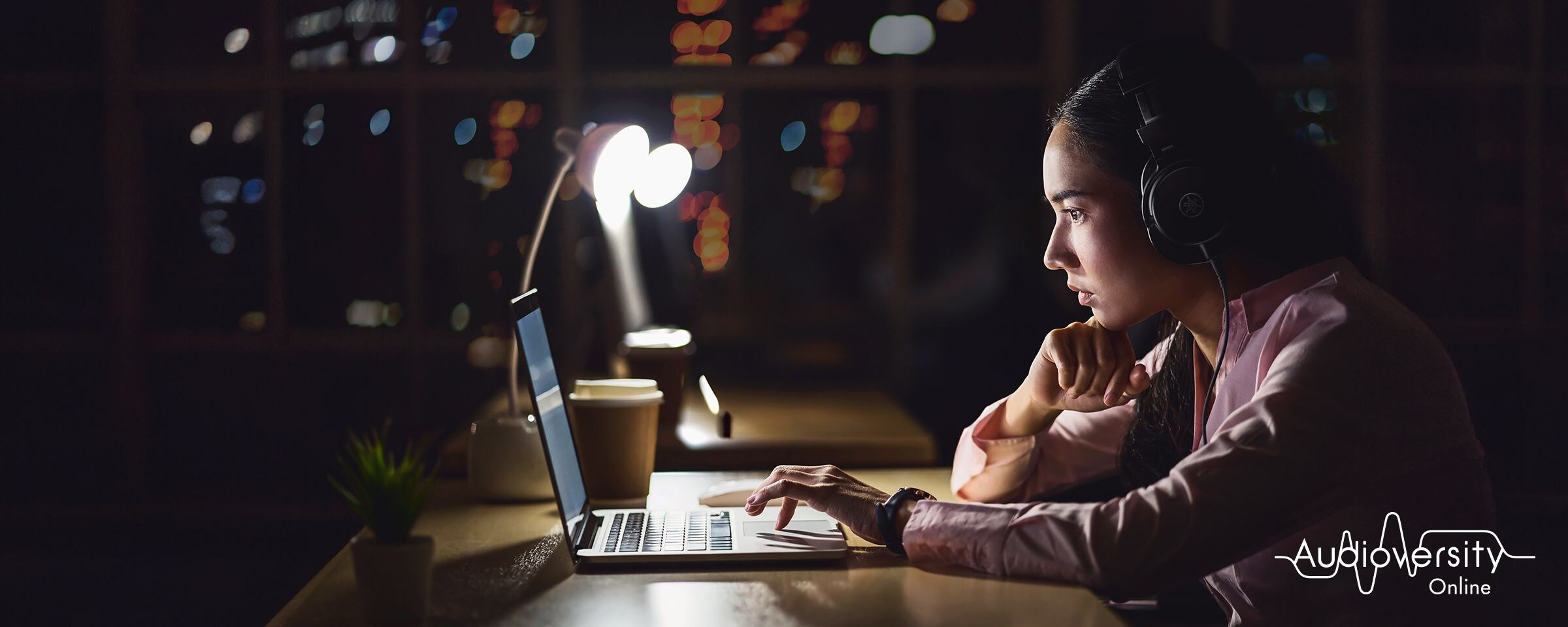Visuel clé pour Audioversity Online : une femme concentrée sur une session de formation en ligne.