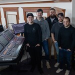 Des membres de l'équipe audio de Christ Community Chapel debout à côté d'une console de mixage Yamaha RIVAGE PM.