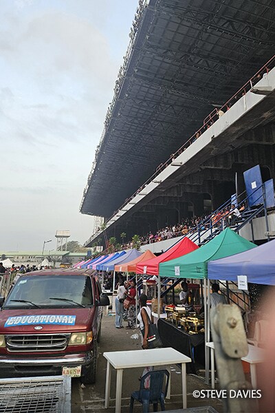 Sièges de tribune et zone des opérations de l'événement avec tentes et participants à The Experience 2025 à Lagos, au Nigeria.