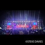 Vue d'ensemble de The Experience 2025 à Lagos, au Nigeria, montrant une grande scène extérieure avec éclairage et écrans vidéo où des artistes se produisent devant une foule de fidèles lors de l'événement annuel de musique gospel.